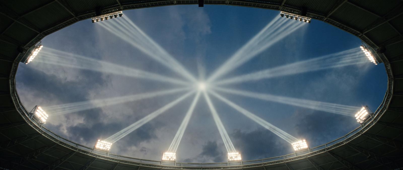 Illustrative photography — stadium floodlights converging on a single point